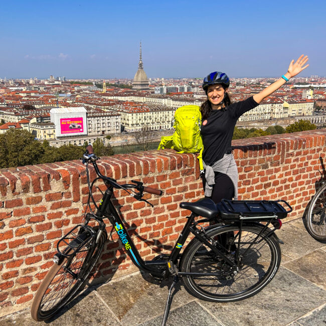 io in tenuta sportiva, con bici e caschetto, su una terrazza panoramica ad ammirare la città di Torino dall'alto